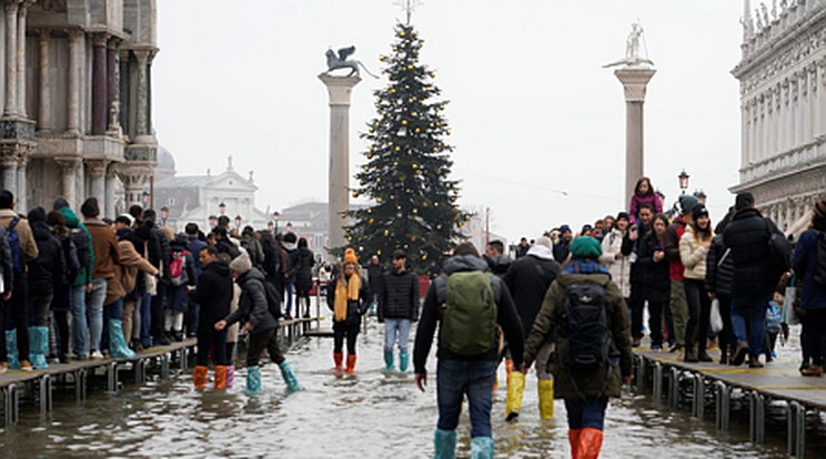 December 10-én száz centiméteres dagály lepte el az olasz várost. A vízben taposva sétálnak a turisták a híres Szent Márk téren az ünnepek előtt. / Fotó: MTI / MTI/AP/Domenico Stinellis