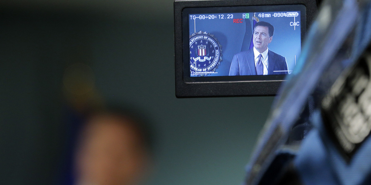 Cameras record FBI Director James Comey during a news conference at the FBI office.