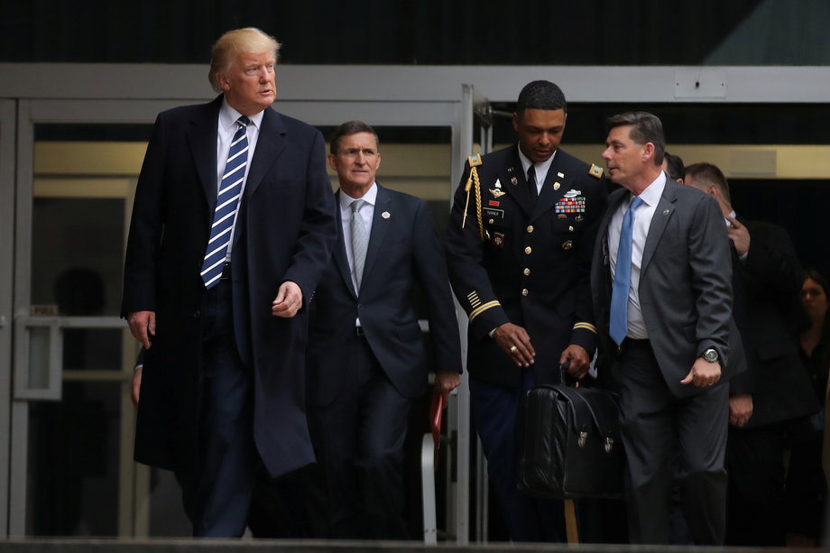 Trump leaving the CIA headquarters accompanied by now former National Security Adviser Michael Flynn, second from left.