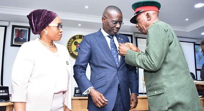 Lagos State Governor, Mr. Babajide Sanwo-Olu (middle) being decorated with the Armed Forces Remembrance Day Emblem by the Chairman, Nigerian Legion, Lagos State Chapter, Col. Samuel Akande (Rtd) (right), while Commissioner for Home Affairs, Mrs Uzamat Akinbile-Yusuf (left) watches on during the launch of the Y2020 Armed Forces Remembrance Emblem at the Lagos House, Ikeja, on Monday. [Twitter/@followlasg]