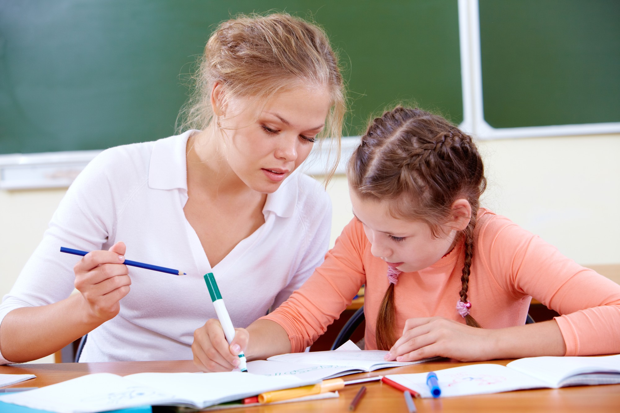Učiteľka pomáha žiakovi pri riešení úloh počas vyučovania matematiky. Nový vedecký výskum ukazuje, že matematické výsledky súvisia nielen so schopnosťou počítať, ale aj s logickým uvažovaním, porozumením jazyku a ďalšími poznávacími schopnosťami. (Ilustračný obrázok)