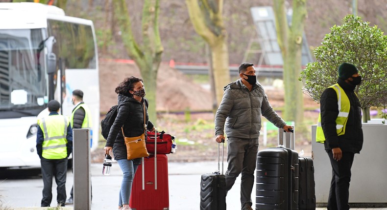 A couple arrive with their luggage by coach to the Holiday Inn hotel near Heathrow Airport in west London on February 17. Since February, travel to the UK from countries on the 'red list' has been subject to mandatory hotel quarantine.
