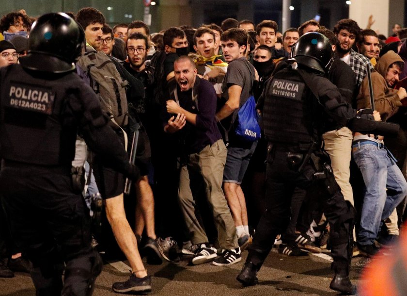 Passengers look as a police officer walks past at Barcelona's airport, during a protest after a verd