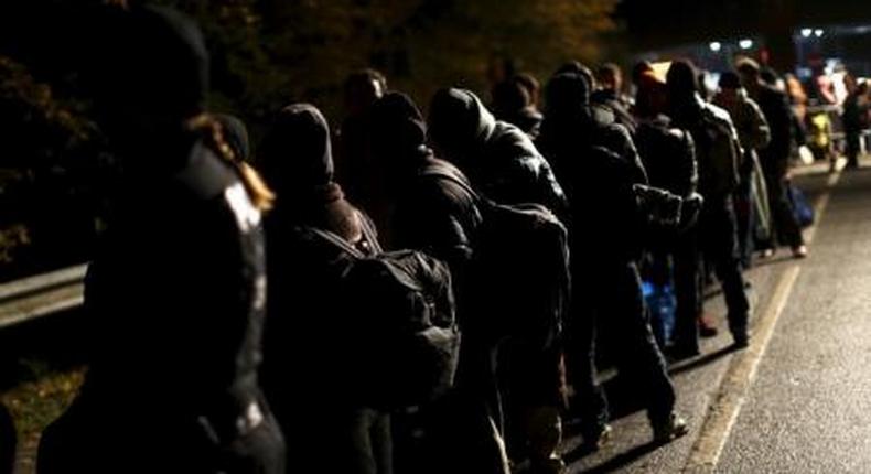 Migrants stay in a queue after crossing the Austrian-German border from Achleiten, Austria, in Passau, Germany, October 29, 2015.