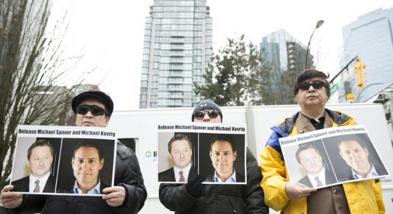 Protesters in Vancouver hold photos of Canadians Michael Spavor and Michael Kovrig who are being detained by China