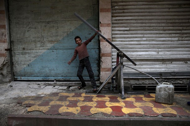 A boy fills a container with water in the town of Douma, eastern Ghouta in Damascus, Syria