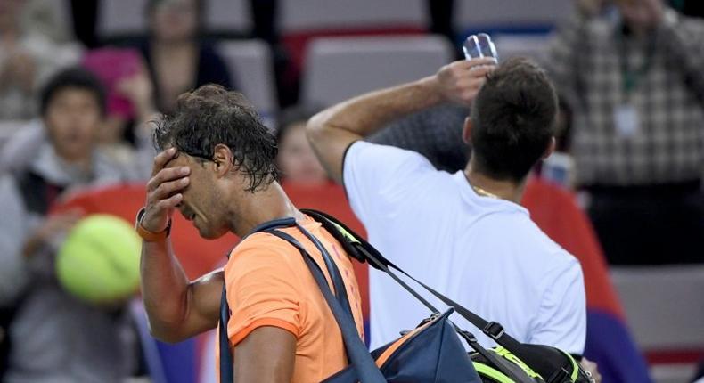 Rafael Nadal of Spain (left) walks off court after defeat by Serbia's Viktor Troicki at the Shanghai Masters on October 12, 2016