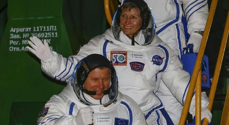 Members of the main crew of the expedition to the International Space Station, Russia's cosmonaut Oleg Novitsky (L) and US astronaut Peggy Whitson wave as they walk to board the rocket at the Russian-leased Baikonur cosmodrome in Baikonur