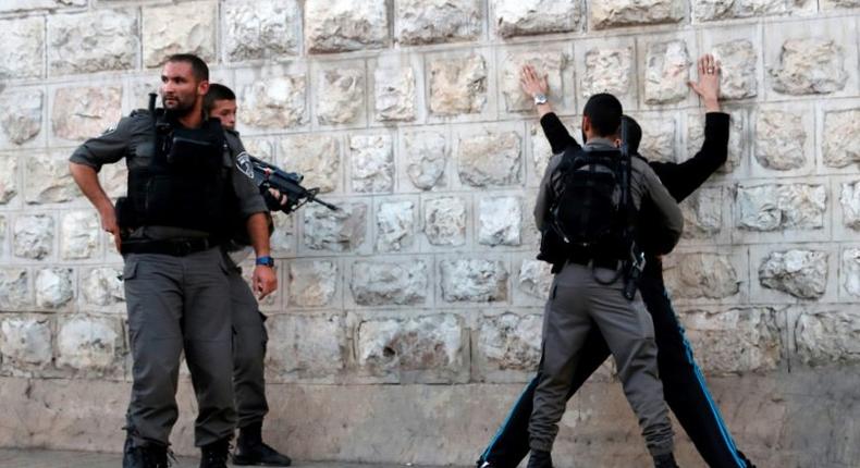 Israeli borderguards search a Palestinian man outside Damascus Gate in Jerusalem's Old City on June 16, 2017, following an attack