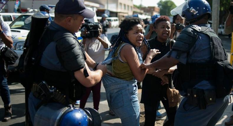 A student from the University of the Witwatersrand (Wits) is detained by South African police forces following clashes during a protest against the university fee increase on September 21, 2016 in Johannesburg