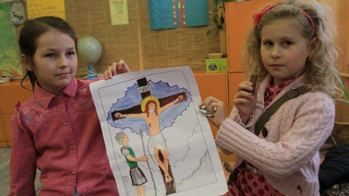 religia szkoła dzieci trzymają obrazek z krzyżem