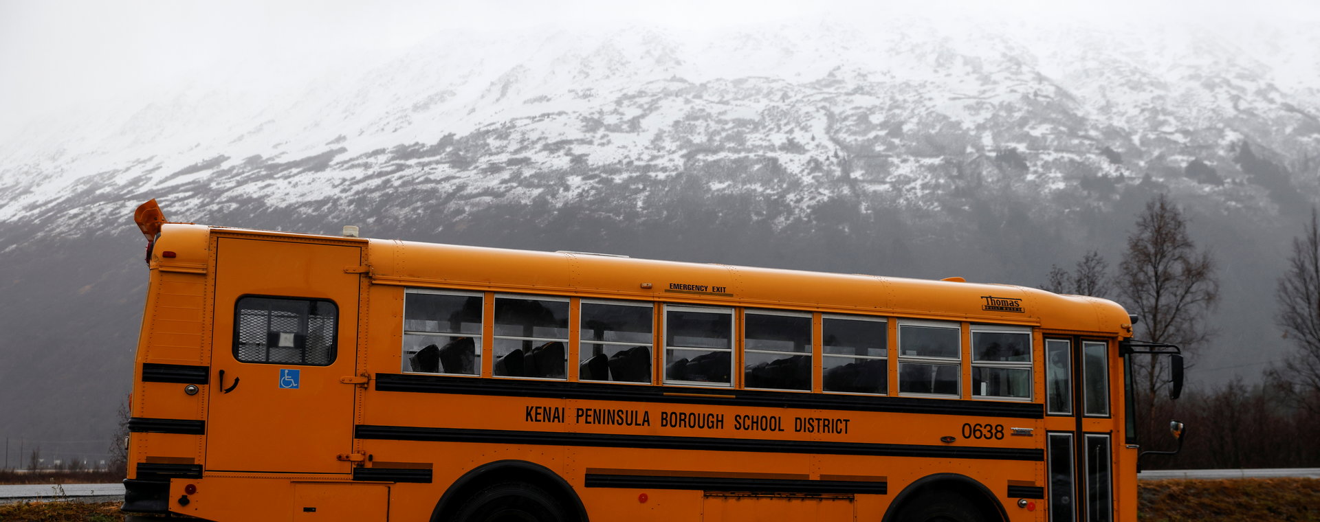 Autobus szkolny na parkingu turystycznego miasteczka w Parku Stanowym Chugach podczas ulewnego deszczu w Girdwood na Alasce. 