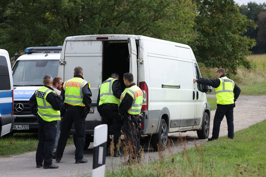 Policja poszukująca nielegalnych imigrantów zagląda do wnętrza furgonetki na punkcie kontrolnym niedaleko granicy z Polską, 25 września 2023 r.