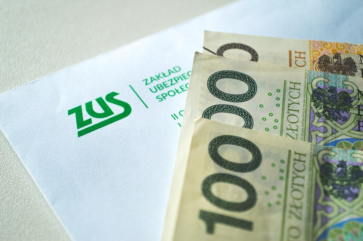 Polskie banknoty, w tle koperta z logo ZUS - ZUS przeliczy czerwcowe emerytury od stycznia 2026.