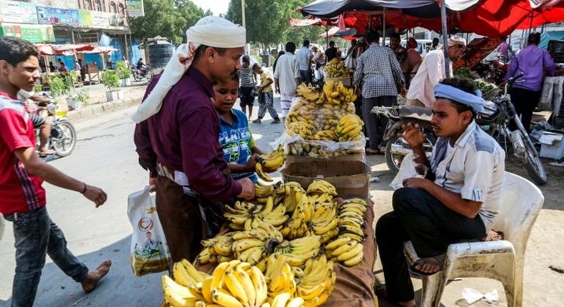 Yemenis buy produce from a fruit peddlar at a market in the Huthi-held Red Sea port of Hodeida on December 14, 2018 a day after warring sides struck a ceasefire accord for the flashpoint city