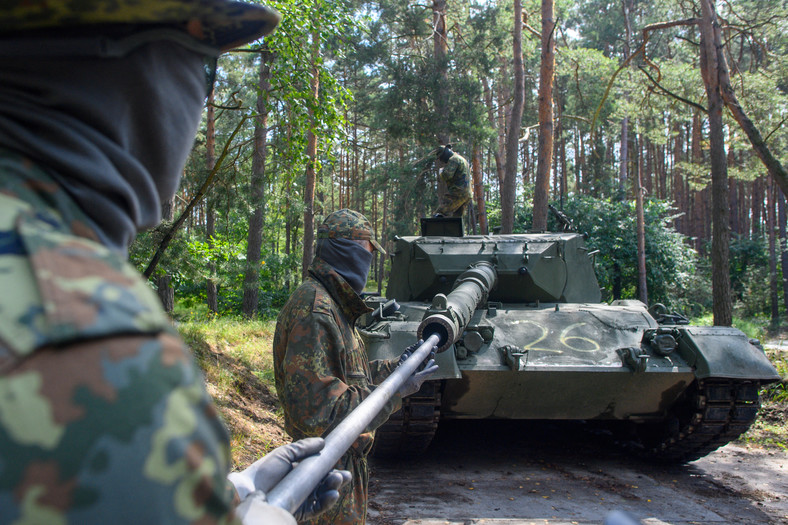 Ukraińscy żołnierze czyszczą lufę czołgu podczas szkolenia w Niemczech