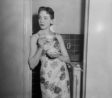 A konyha ajtajában állva, virágos ruhájában és egy csésze teával a kezében Julie Andrews egyszerre sugároz eleganciát és természetességet – mintha mindig is ebben a szerepben tündökölt volna.