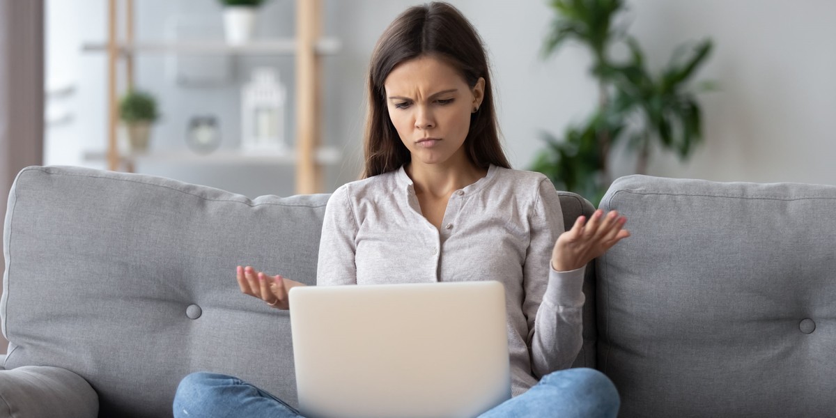 Confused young woman looking on laptop feels bewildered by reading online news