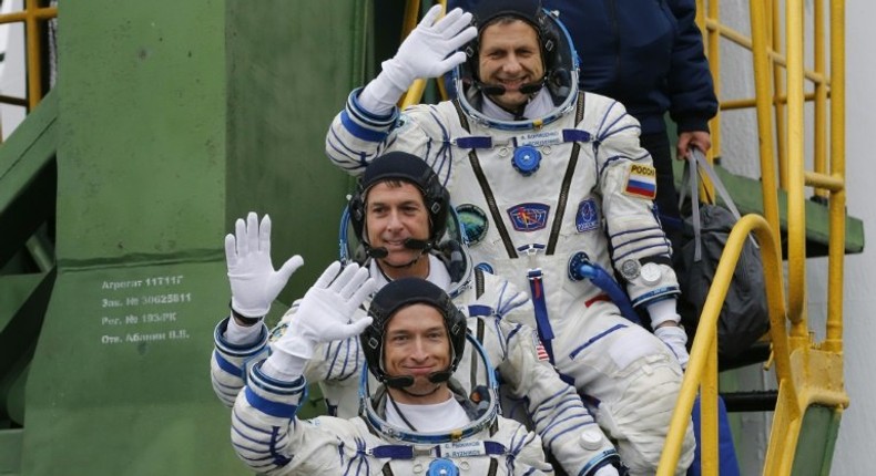 Russian cosmonauts Sergei Ryzhikov (bottom) and Andrei Borisenko (top) and US astronaut Shane Kimbrough wave as they board the Soyuz MS-02 spacecraft at the Russian-leased Baikonur cosmodrome on October 19, 2016