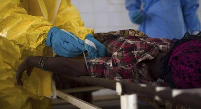 Medical staff take a blood sample from a suspected Ebola patient at the government hospital in Kenema, July 10, 2014. REUTERS/Tommy Trenchard