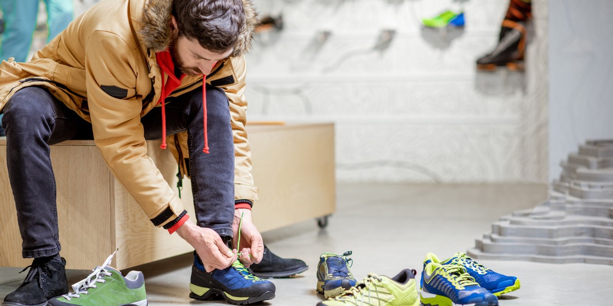 Man trying shoes for hiking in the shop