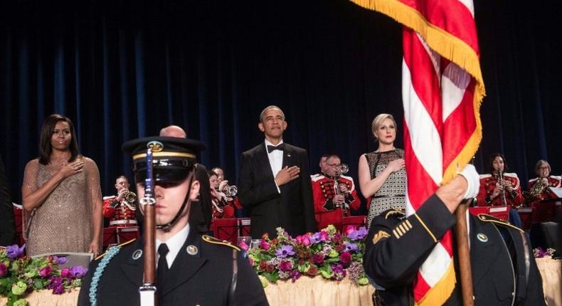 US President Barack Obama (C), First Lady Michelle Obama (L), and White House Correpondents' Association president Carol Lee (R) attend the 102nd White House Correspondents' Association Dinner in Washington, DC, in 2016