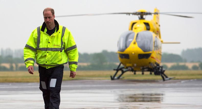 Prince William walks away from one of the East Anglian Air Ambulance's helicopters at Cambridge Airport.