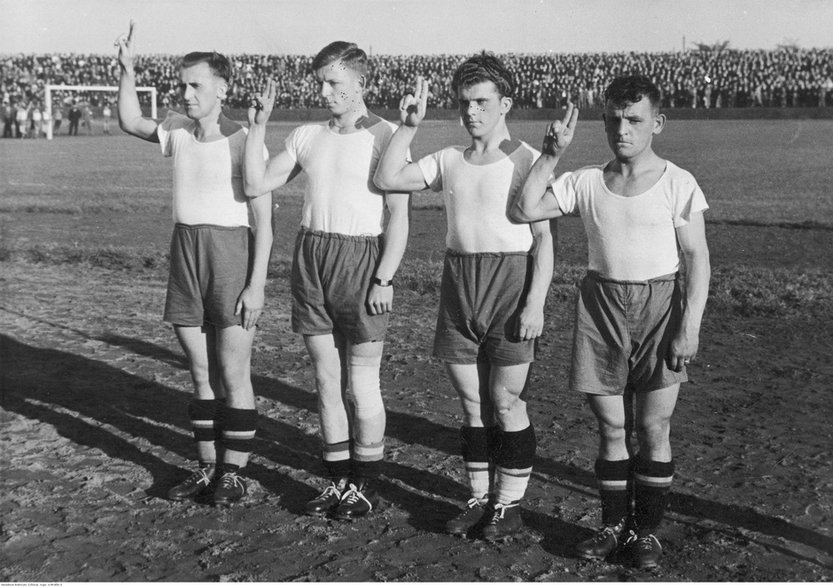 Jucătorii de fotbal depun jurământ în timpul pauzei meciului de fotbal Rush Wilkie Hajduki - Warta Poznan.  În picioare din stânga: Gerard Woodars, Ernest Wilimowski, Edmund Giemsa și Carol Dziwisz