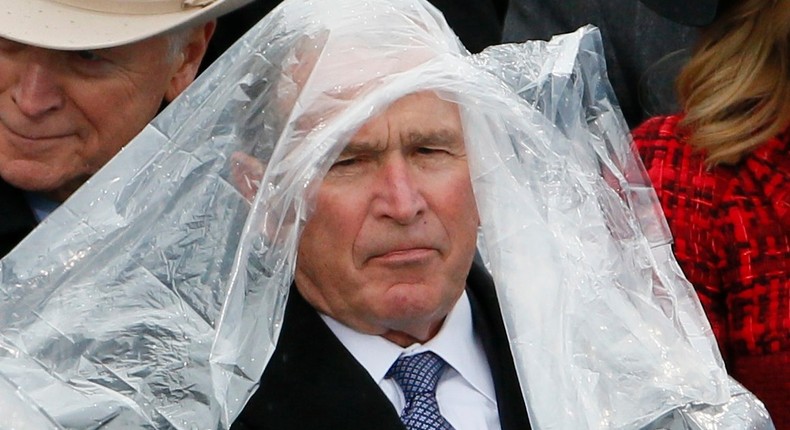 Former President George W. Bush keeps covered under the rain during the inauguration ceremonies swearing in Donald Trump as the 45th president of the United States on the West front of the U.S. Capitol in Washington, U.S., January 20, 2017.