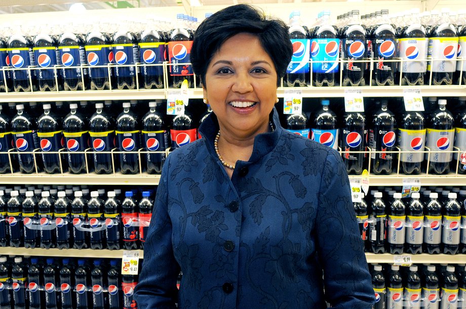 PepsiCo CEO Indra Nooyi stands in front of Pepsi products.