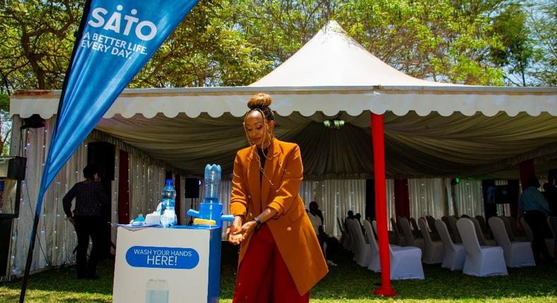 Ms Janet Mbugua, Founder of the Inua Dada Foundation and MC of the day demonstrates handwashing using a SATO tap, an innovation by Lixil