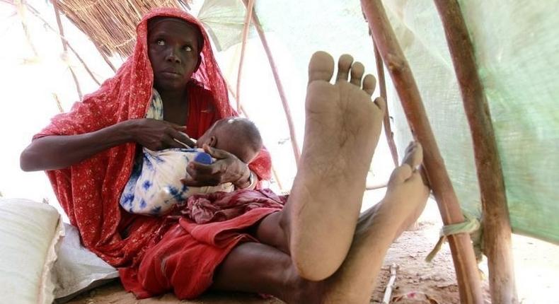 An internally displaced woman feeds her child inside their makeshift shelter structure at the Qansahaley settlement camp in Dollow town along the Somalia-Ethiopia border, August 30, 2011. REUTERS/Thomas Mukoya