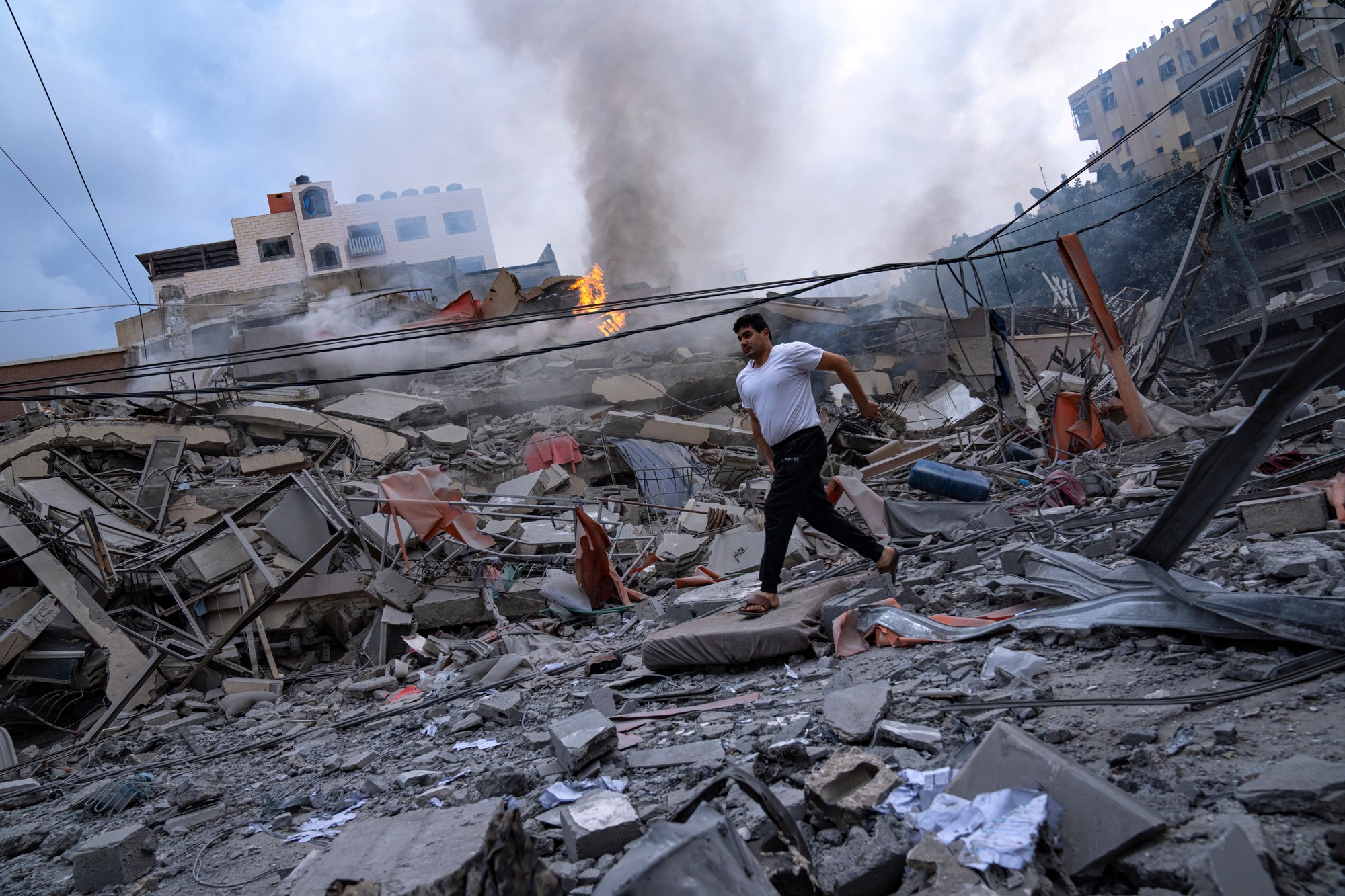 Palestínčania kráčajú medzi vyskytujúcimi sa ruinami po izraelských leteckých útokoch, ktoré sa týkali zrovnania so zemou, časť štvrte v meste Gaza,  konkrétne v utorok 10. októbra 2023.