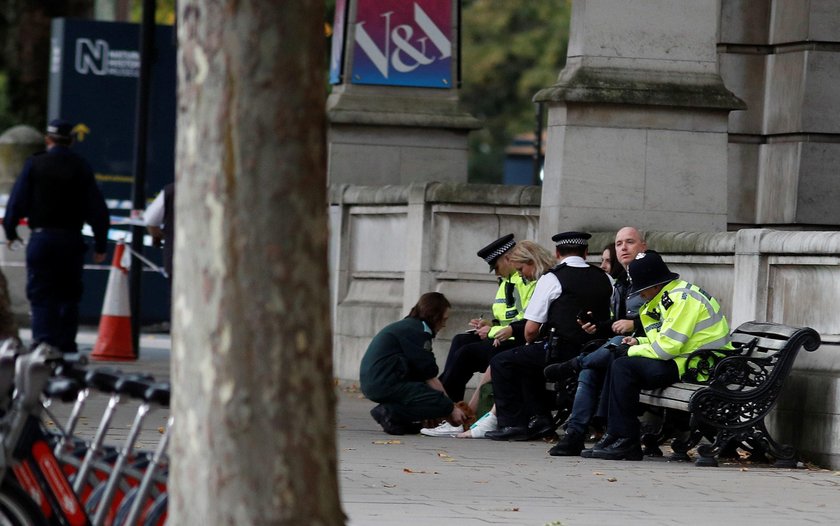 Emergency services personnel wheel a woman in a wheelchair to a nearby ambulance near the Natural Hi