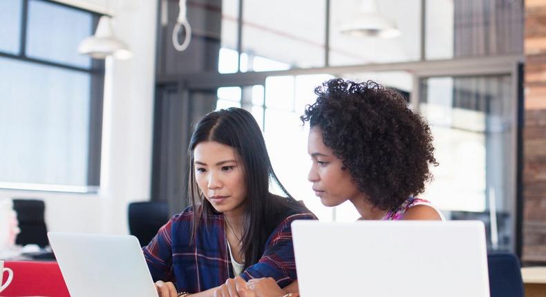 two women working together on a laptop