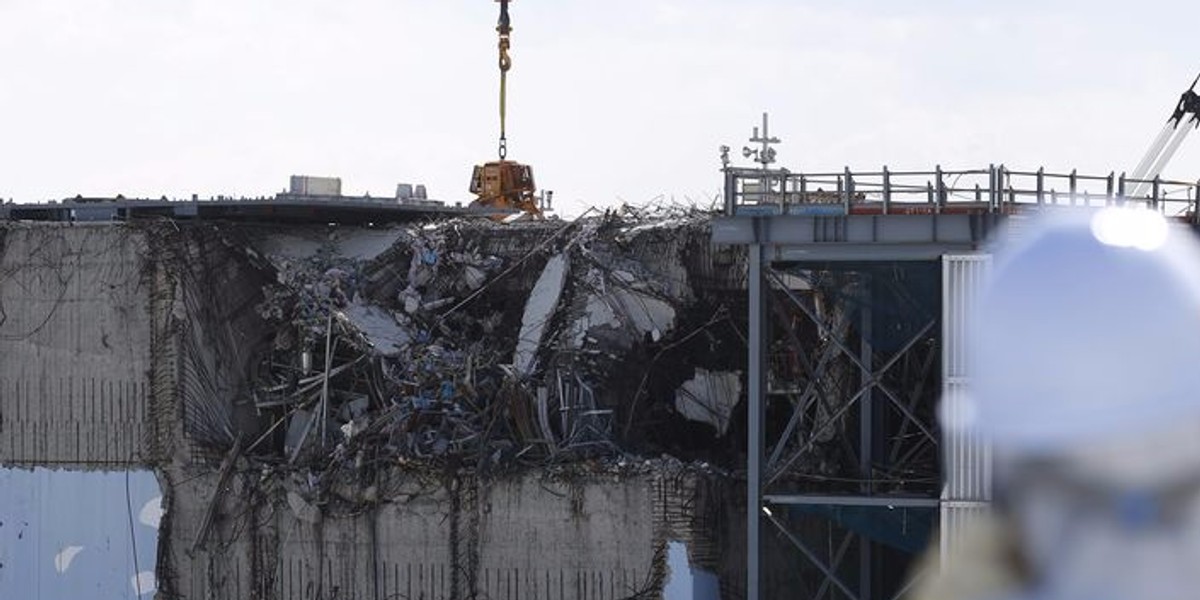 File photo of a member of the media looking at the No. 3 reactor building at Tokyo Electric Power Co's tsunami-crippled Fukushima Daiichi nuclear power plant in Okuma town