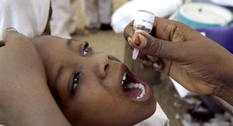 A health worker gives a child an oral polio vaccine in Kano, Nigeria. 