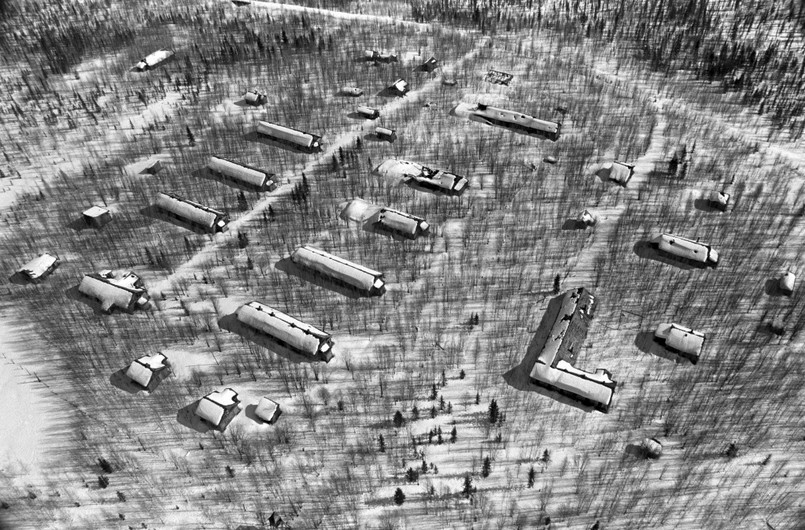 Typowy obóz dla blisko 500 więźniów. Siedem baraków w dwóch rzędach dla około 80 więźniów każdy, pomiędzy nimi droga prowadząca do linii kolejowej przez wachtę do łagrowej jadalni (z lewej). Dwa małe budynki w lewym dolnym rogu to prawdopodobnie piekarnia i łaźnia. Z prawej, za ogrodzeniem obozu, budynek strażników i administracji obozowej (w kształcie litery L) oraz magazyny narzędzi i żywności. Od lat dwudziestych do pięćdziesiątych XX wieku w łagrach przetrzymywano ponad 20 milionów skazańców. Życie straciło tam 2 miliony więźniów.