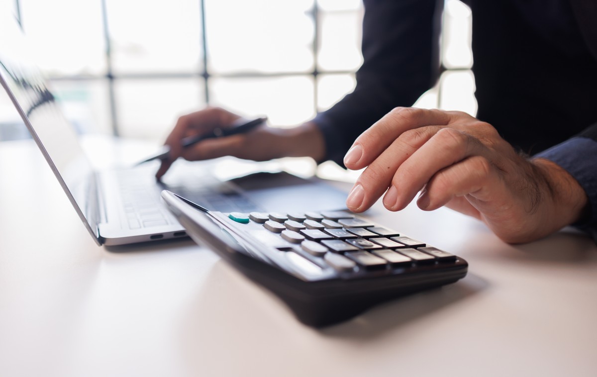 Accountant,Man,Hang,Using,Calculator,To,Calculate,Company,Finances,At