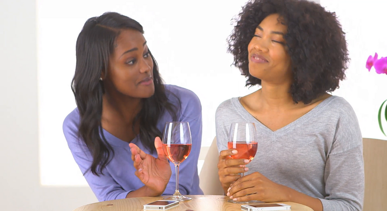 Friends having a chat over a bottle of wine [Credit: Video Blocks]