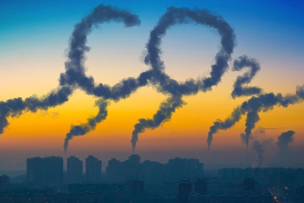 Evening view of the industrial landscape of the city with smoke emissions from chimneys at sunset CO2.