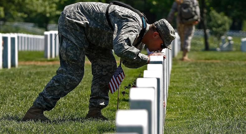 U.S. Army Capt. Ed Arntson of Chicago, Illinois kisses the grave of Staff Sgt. Henry Linck, who was killed in Iraq in 2006, in Arlington National Cemetery May 21, 2009 in Arlington, Virginia.