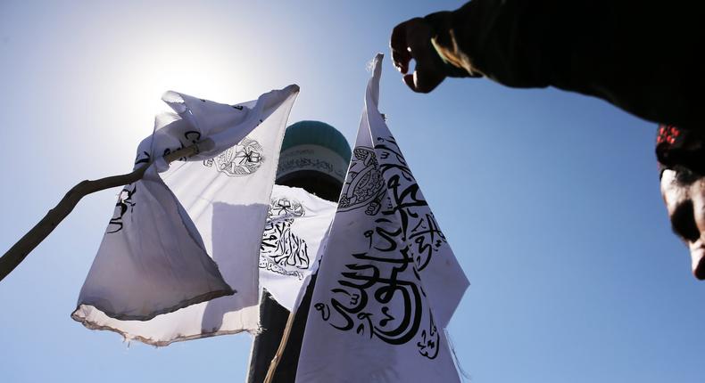 Taliban fighters stand next to Taliban flag on August 31, 2022.Bilal Guler/Anadolu Agency via Getty Images