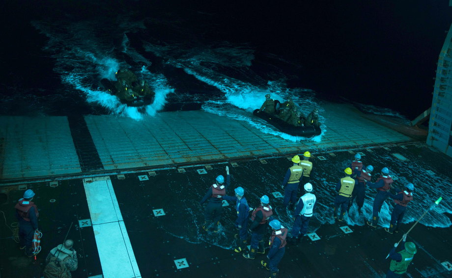 Sailors recover combat rubber raiding craft with Marines assigned to the 31st Marine Expeditionary Unit during night operations in the well deck of the forward-deployed amphibious-assault ship USS Bonhomme Richard.