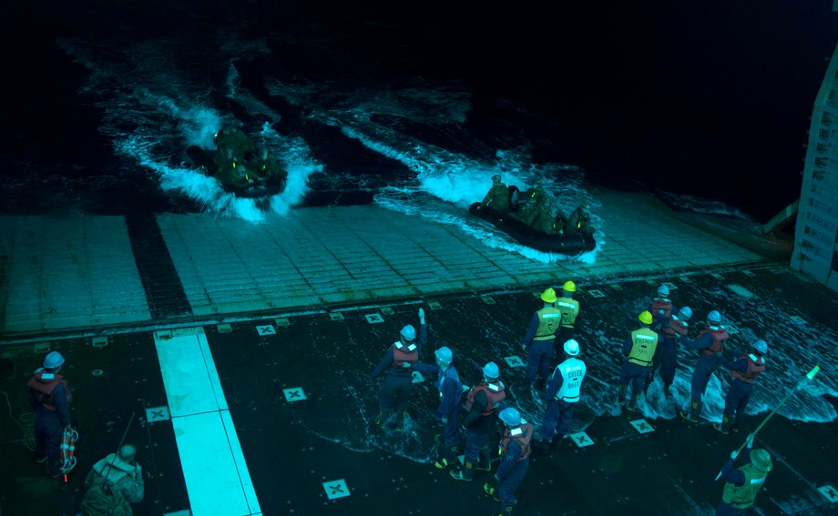 Sailors recover combat rubber raiding craft with Marines assigned to the 31st Marine Expeditionary Unit during night operations in the well deck of the forward-deployed amphibious-assault ship USS Bonhomme Richard.