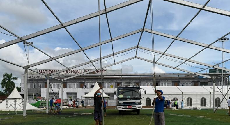 Workers building temporary shelters for coronavirus patients on a football pitch in Yangon, where new infections have spiked prompting opposition parties to call for a postponement of elections due in November