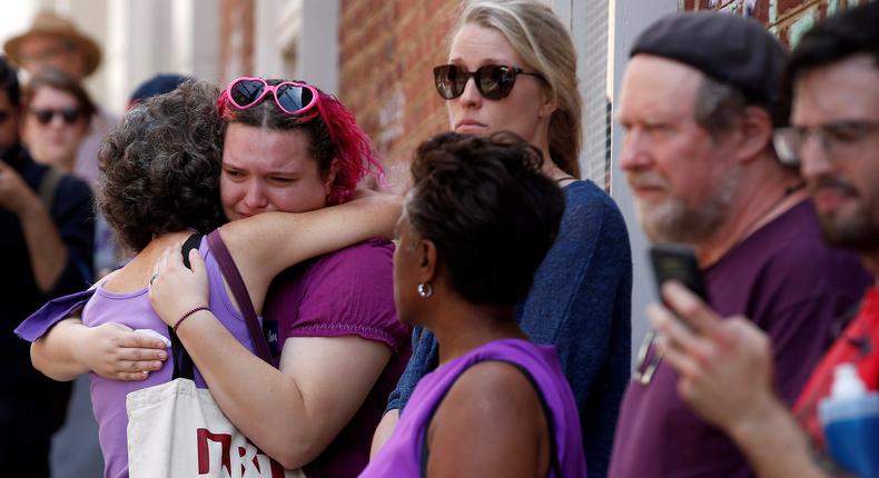 Be safe and 'pray for the best.' Women comfort each other at the site where Heather Heyer was killed.