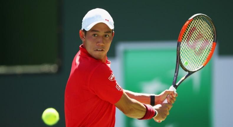 Kei Nishikori of Japan plays a backhand against Gilles Muller of Luxembourg in their third round match during day nine of the BNP Paribas Open at Indian Wells Tennis Garden on March 14, 2017