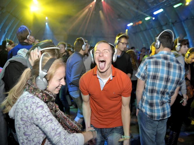 Zabawa w hangarze Silent Disco przy muzyce, którą słychać tylko przez słuchawki