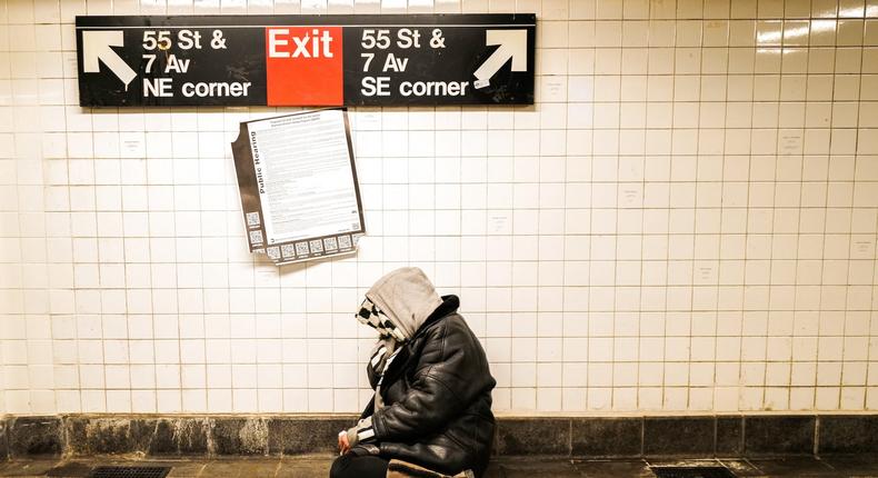 A homeless person sits on the ground in a subway station in Manhattan on February 20, 2024.CHARLY TRIBALLEAU/Getty Images